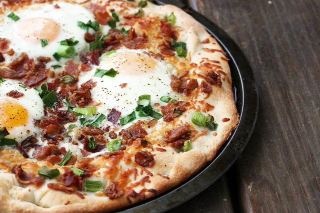 Breakfast pizza recipe, topped with bacon, eggs, and mozzarella. Click through for recipe.