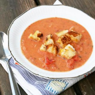 Creamy garlic tomato soup with grilled cheese croutons. The best combo ever, in one delicious dish.