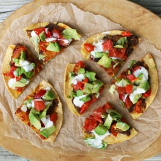 Mexican-style pizzettes, made out of corn tortillas, refried beans, and other yummy ingredients. Click through for recipe!