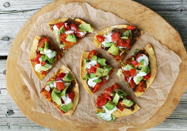 Mexican-style pizzettes, made out of corn tortillas, refried beans, and other yummy ingredients. Click through for recipe!