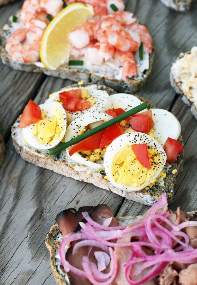 Open-faced sandwiches with hard-boiled egg, tomato, and chive.