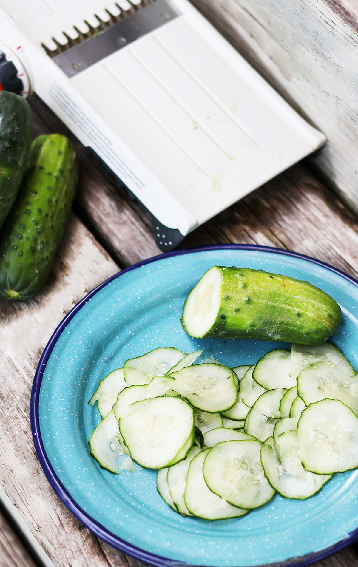 How to make freezer pickles: Use a mandolin slicer to slice the pickling cucumbers.