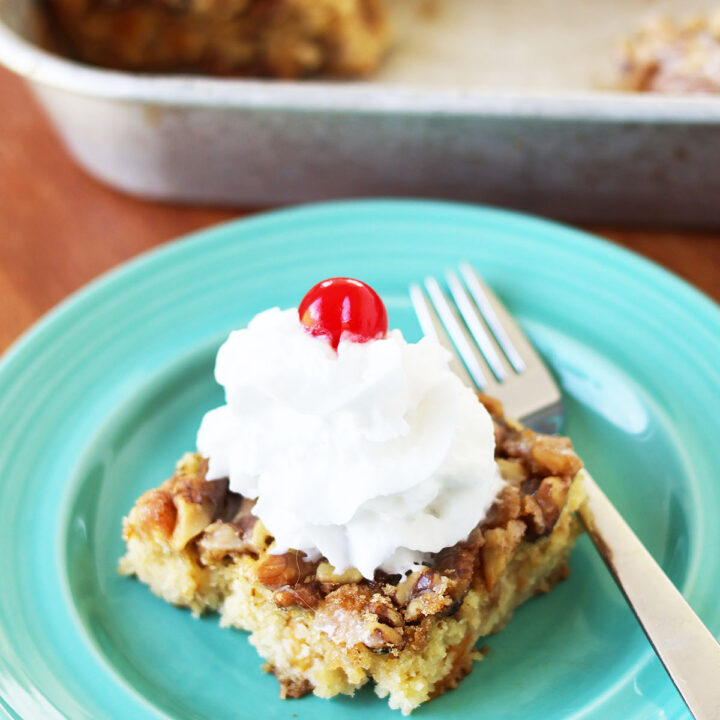 Fruit cocktail cake with whipped cream and a maraschino cherry